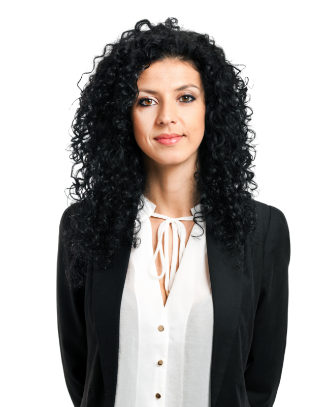 Vrouw met zwart krullend haar heeft een witte blouse aan en daar overheen een zwarte blazer. 